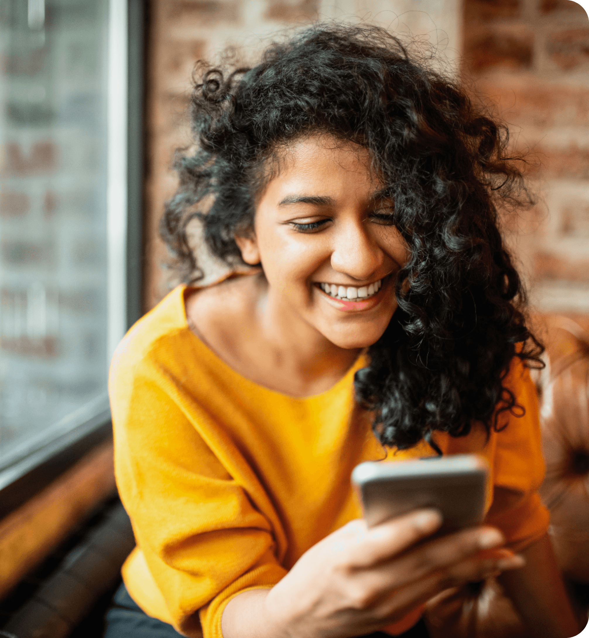 A lady holding a phone smiling